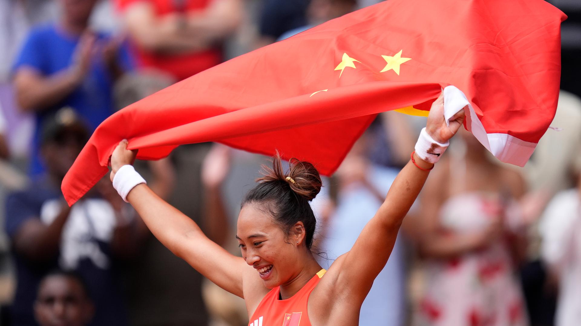 Tennisspielerin Zheng Qinwen hält eine chinesische Flagge nach ihrem Sieg über die Kroatin Donna Vekic im Finale des Dameneinzels bei den Olympischen Sommerspielen 2024.