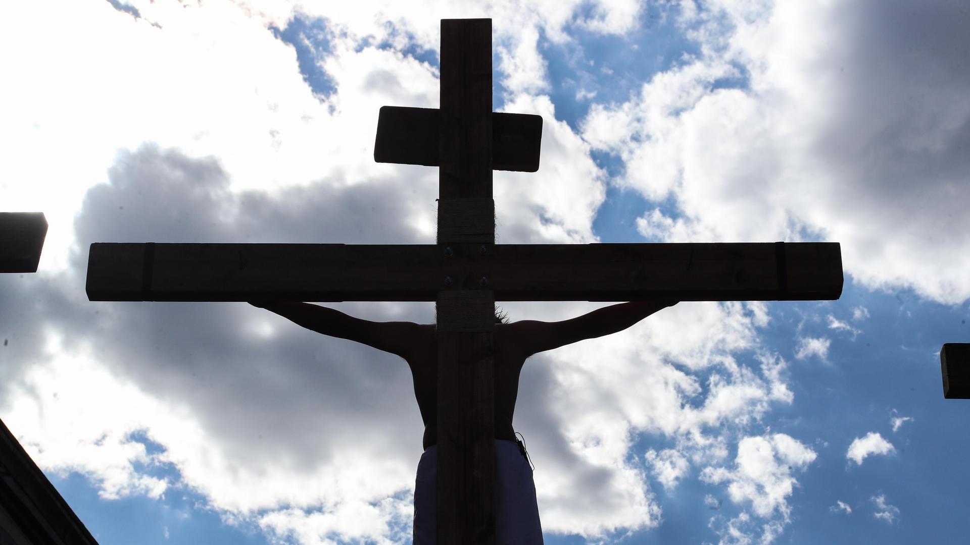 Die Kreuzigung Jesu inmitten des blauen Himmels und von weißen Wolken Die Kreuzigung Jesu inmitten des blauen Himmels und von weißen Wolken