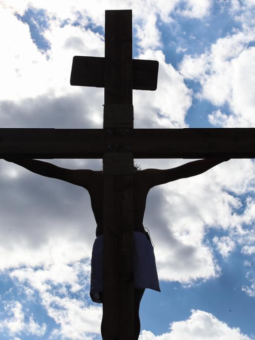 Die Kreuzigung Jesu inmitten des blauen Himmels und von weißen Wolken 