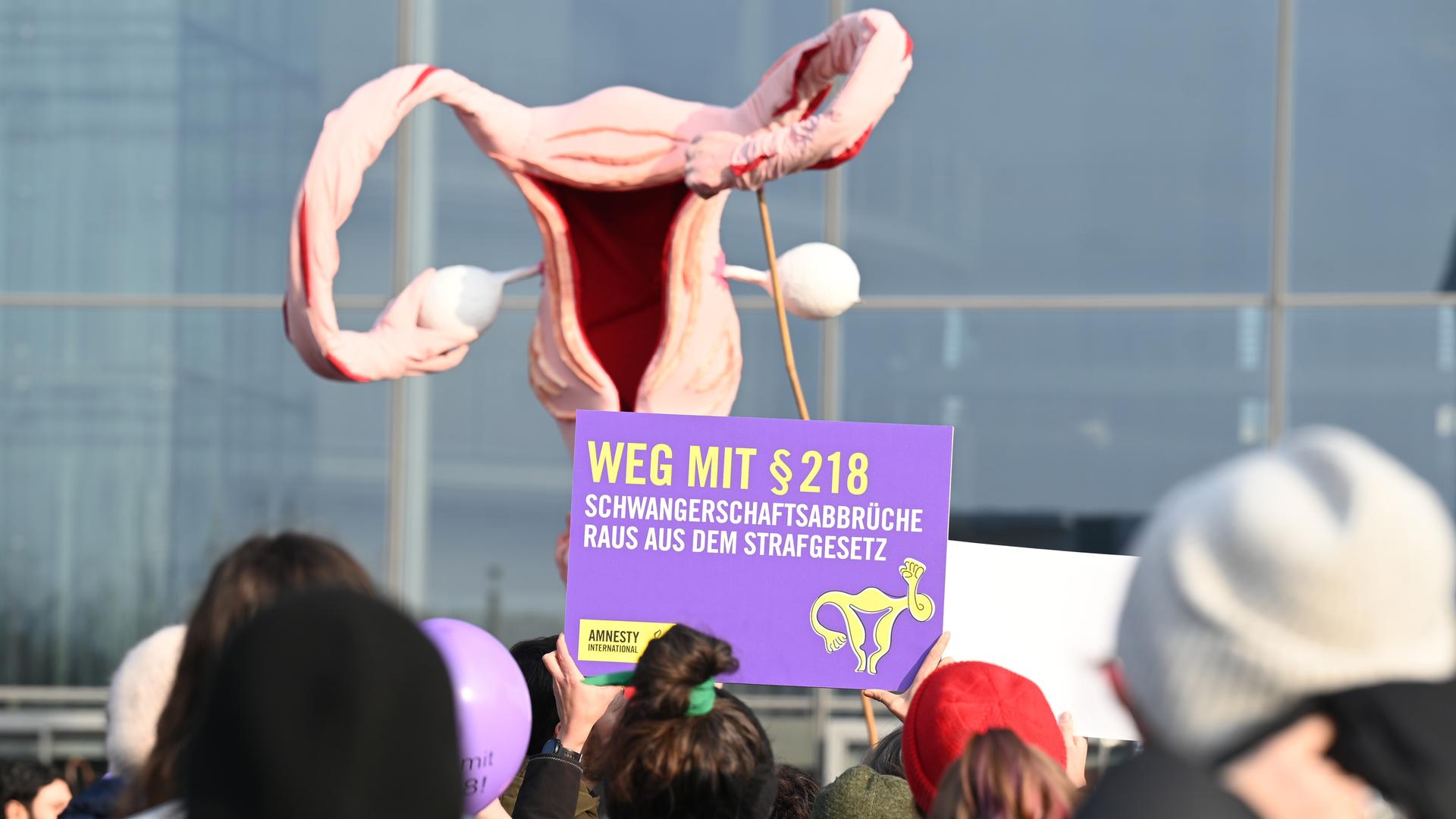 Mit einem überdimensionalen Uterus demonstrieren Menschen für die Legalisierung von Schwangerschaftsabbrüchen. Ein Plakat trägt die Aufschrift "Weg mit § 218".