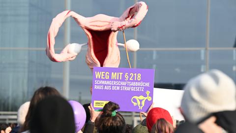 Mit einem überdimensionalen Uterus demonstrieren Menschen für die Legalisierung von Schwangerschaftsabbrüchen. Ein Plakat trägt die Aufschrift "Weg mit § 218".