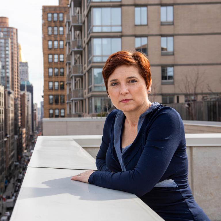 Heike Buchter. Eine Frau mit kurzen Haaren steht auf einer Dachterrasse in New York.