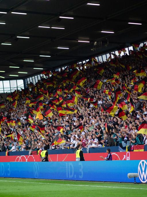 Fans von Deutschland jubeln über das Tor zum 1:0 und schwenken Fahnen/Flaggen  