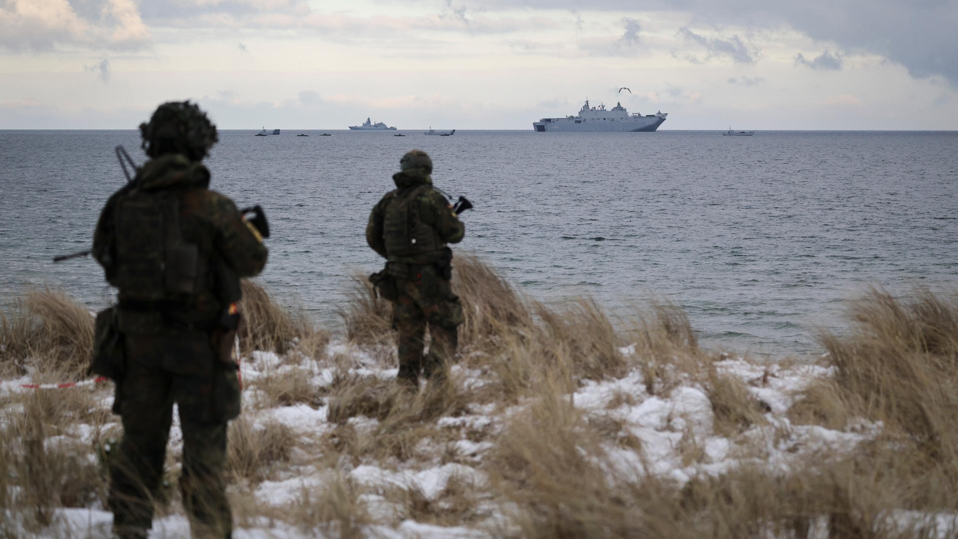 Soldaten der Bundeswehr stehen an der Küste auf dem bei einem Medientermin zum Nato-Manöver "Steadfast Dart 26" auf dem Truppenübungsplatz Putlos. Im Hintergrund das amphibische Angriffsschiff L400 Anadolou aus der Türkei.