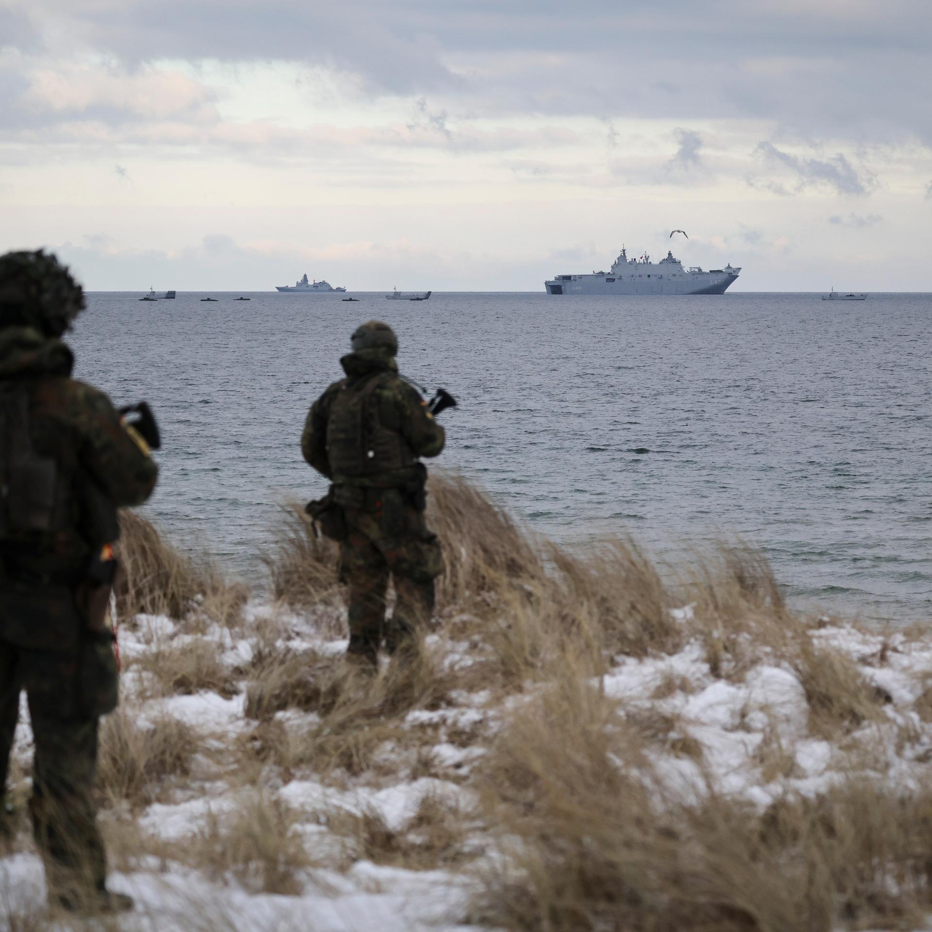 Soldaten der Bundeswehr stehen an der Küste auf dem bei einem Medientermin zum Nato-Manöver "Steadfast Dart 26" auf dem Truppenübungsplatz Putlos. Im Hintergrund das amphibische Angriffsschiff L400 Anadolou aus der Türkei.