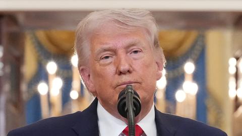 USPresident Donald Trump steht am Rednerpult und spricht in ein Mikrofon.