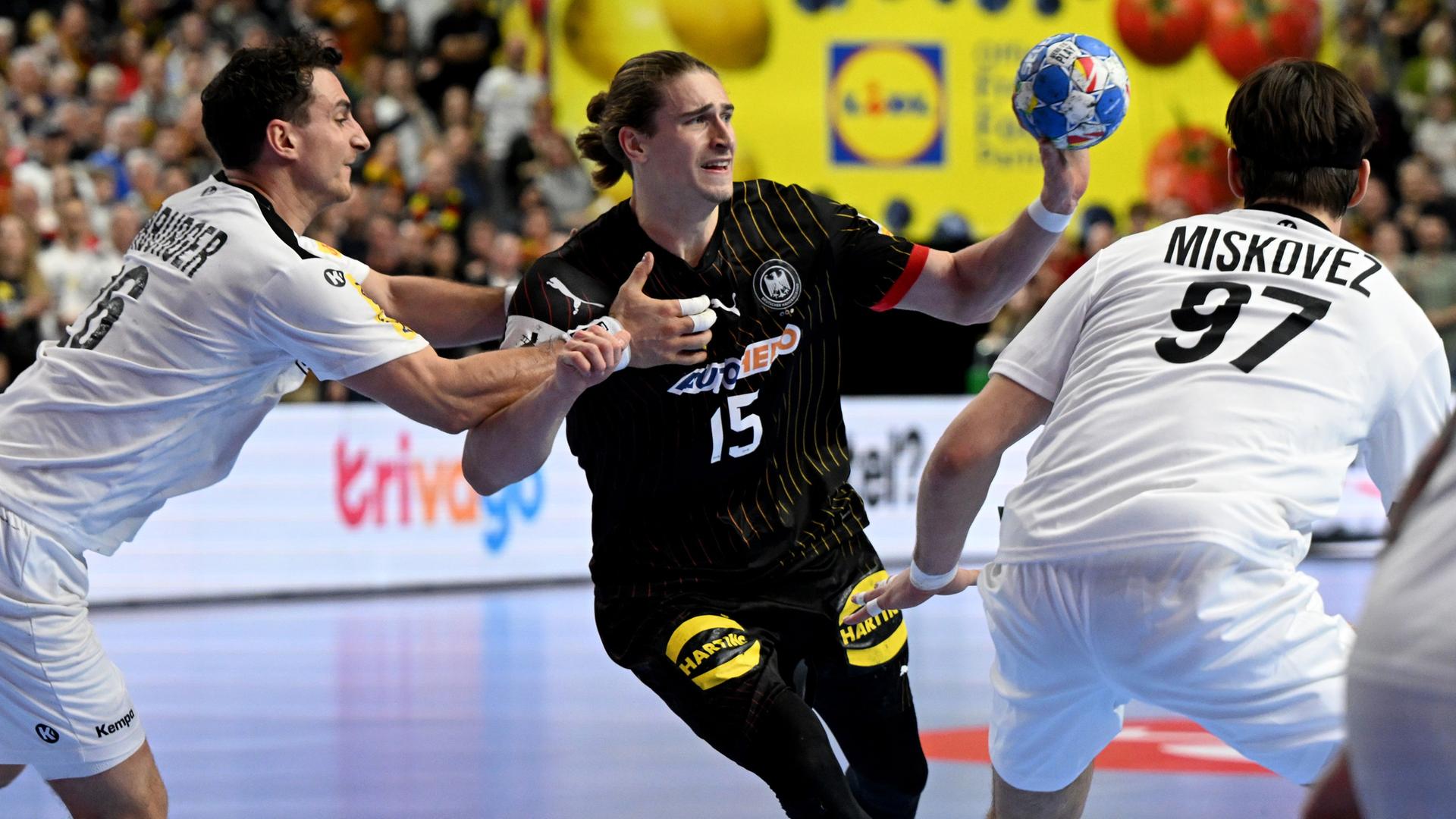 Handball: Deutschlands Juri Knorr (M) wird von Österreichs Lukas Herburger (l) und Österreichs Michael Miskovez verteidigt