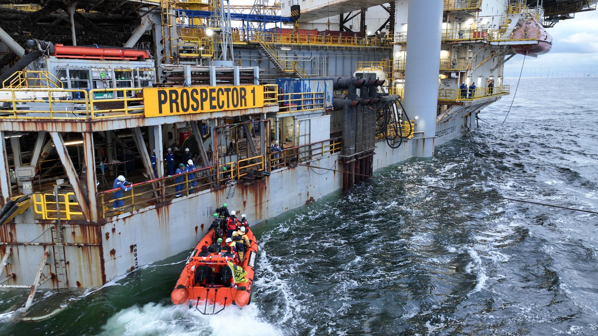 Ein Schlauchboot von Greenpeace vor einer Bohrplattform in der Nordsee.