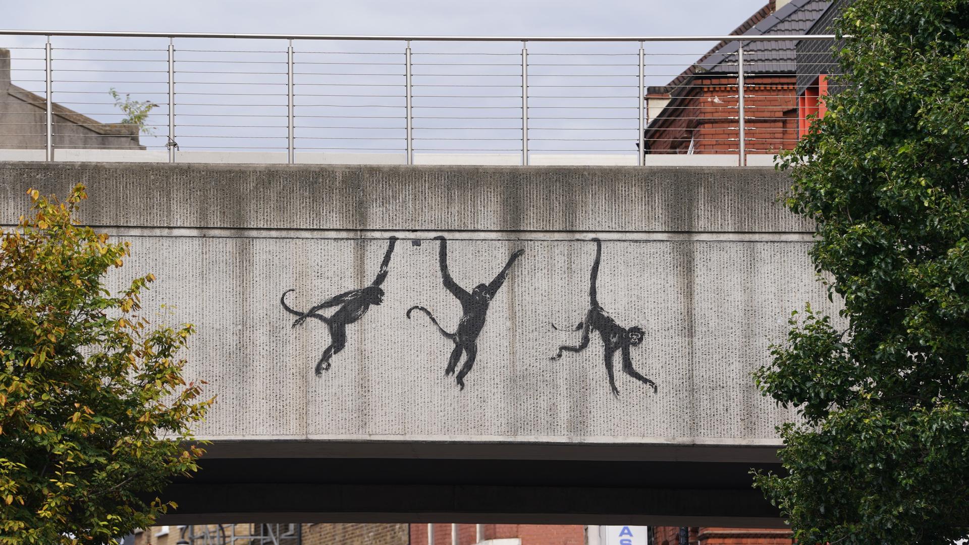  Ein Blick auf Banksys neues Kunstwerk, das drei Affen auf einer Brücke in der Brick Lane zeigt.