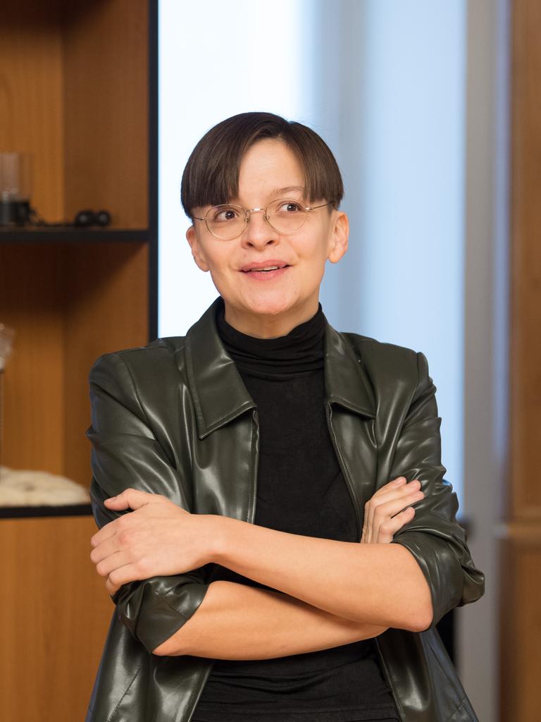 Die Künstlerin Henrike Naumann vor einem Regal mit deutschen Devotialien. 