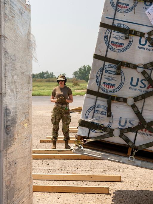 US-Soldatin steht neben einer Lieferung von USAID (11.9.2022, Pakistan) 