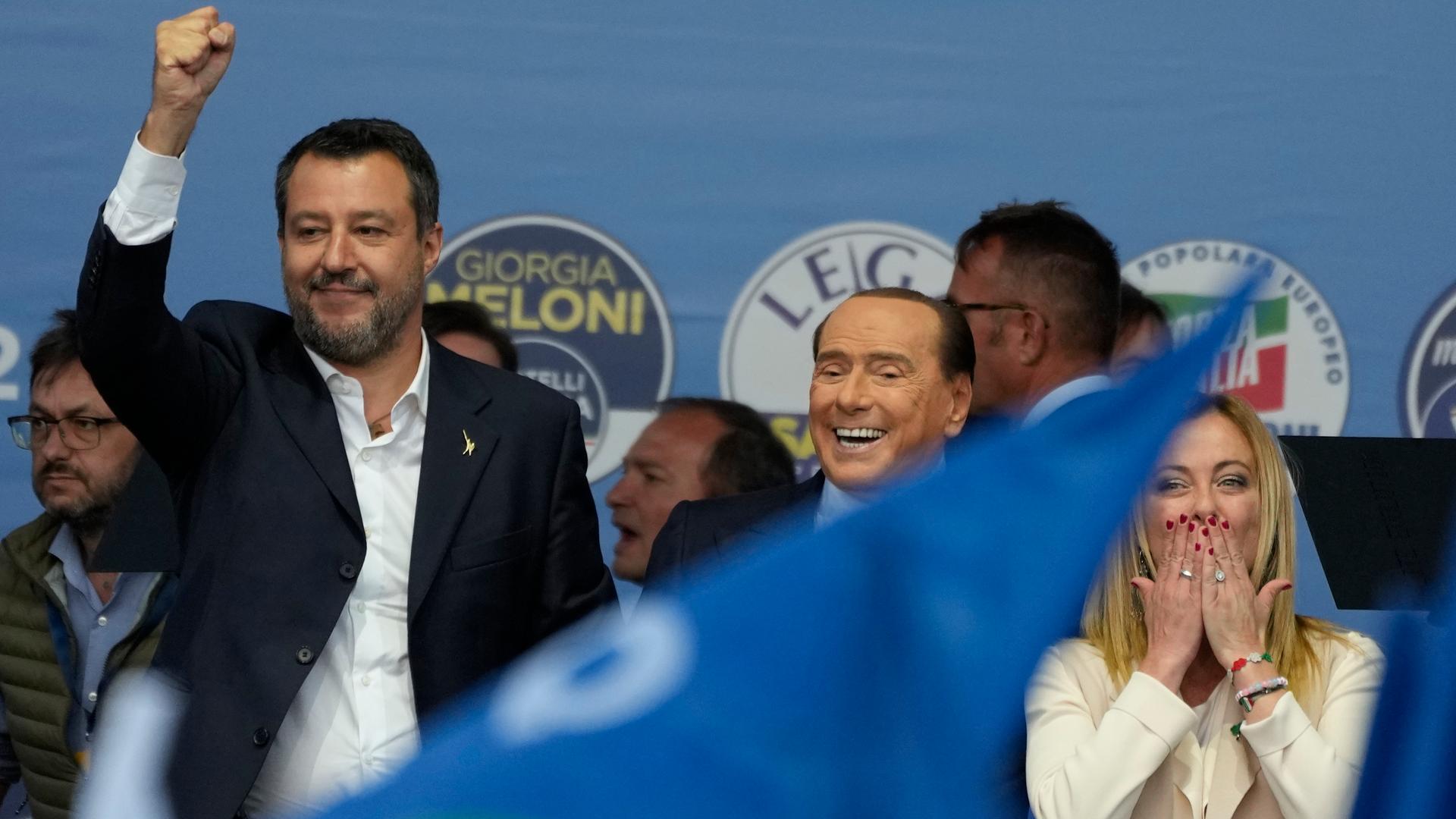 Matteo Salvini, Silvio Berlusconi und Giorgia Meloni stehen auf einer Bühne.