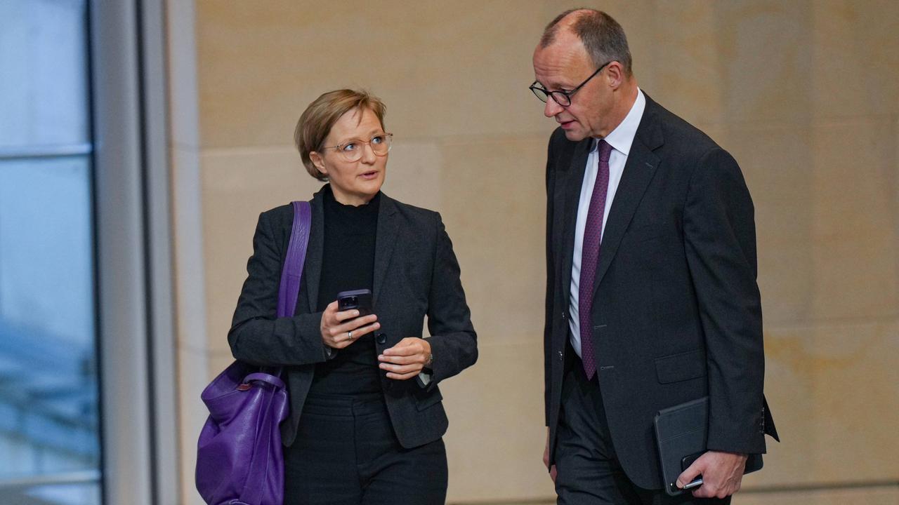 Franziska Brantner, Bundesvorsitzende der Grünen, schaut Friedrich Merz, Chef der CDU, an. Beide scheinen sich zu unterhalten, während sie durch das Plenum im Bundestag laufen.