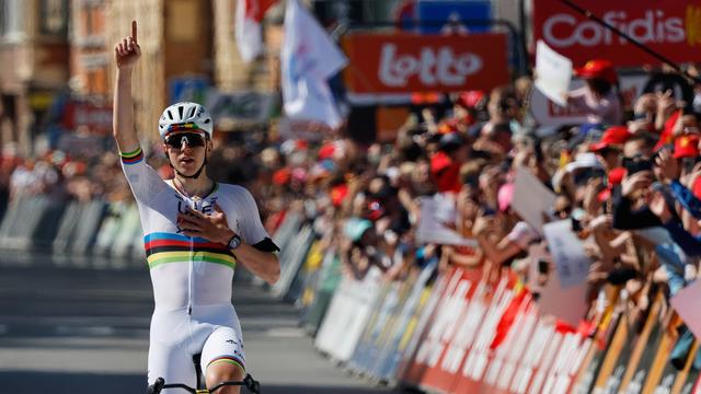 Der Rad-Sportler Tadej Pogacar überquert die Ziel-Linie und reckt  dabei eine Hand in den Himmel. 