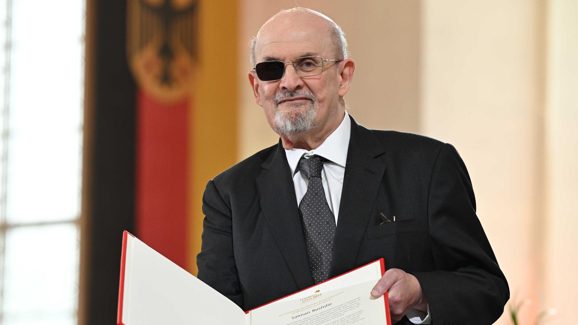 Der britisch-indische Autor Salman Rushdie hält bei der Verleihung des Friedenspreisesi in der Paulskirche eine Urkunde in der Hand