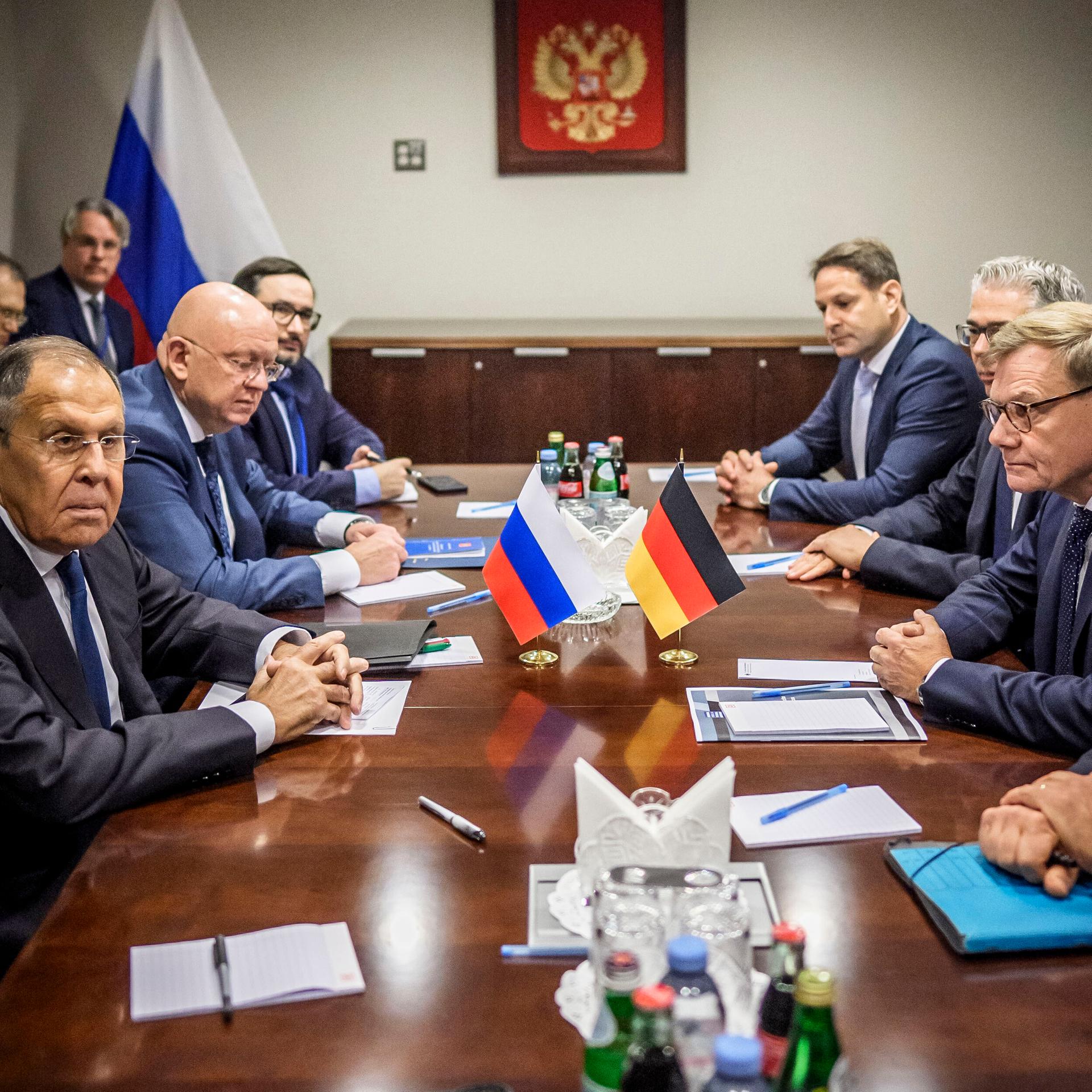 Bundesaußenminister Wadephul trifft seinen russischen Amtskollegen Lawrow in New York. Beide sitzen sich an einem großen Tisch gegenüber, an dem auch noch andere Personen sitzen. 
