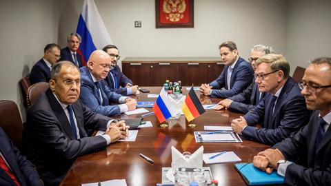 Bundesaußenminister Wadephul trifft seinen russischen Amtskollegen Lawrow in New York. Beide sitzen sich an einem großen Tisch gegenüber, an dem auch noch andere Personen sitzen. 