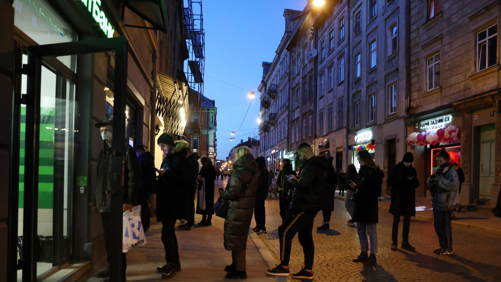 Menschen stehen Schlange vor einem Geldautomaten in Lviv (Lemberg)
