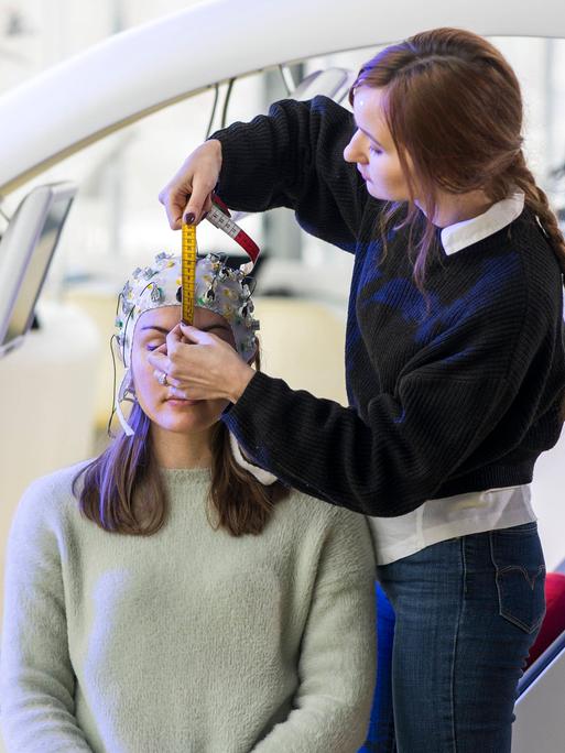 Eine Person bringt auf dem Kopf einer anderen Person ein Brain-Computer-Interface an. Das Cottbuser Startup Zander Laboratories forscht und entwickelt solche Geräte. Eine Person bringt auf dem Kopf einer anderen Person ein Brain-Computer-Interface an. Das Cottbuser Startup Zander Laboratories forscht und entwickelt solche Geräte.