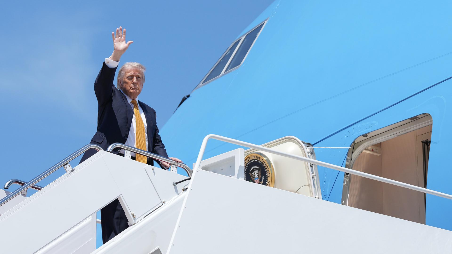 Das Foto zeigt Präsident Trump, als er eine Treppe zu einem Flugzeug hochgeht. 