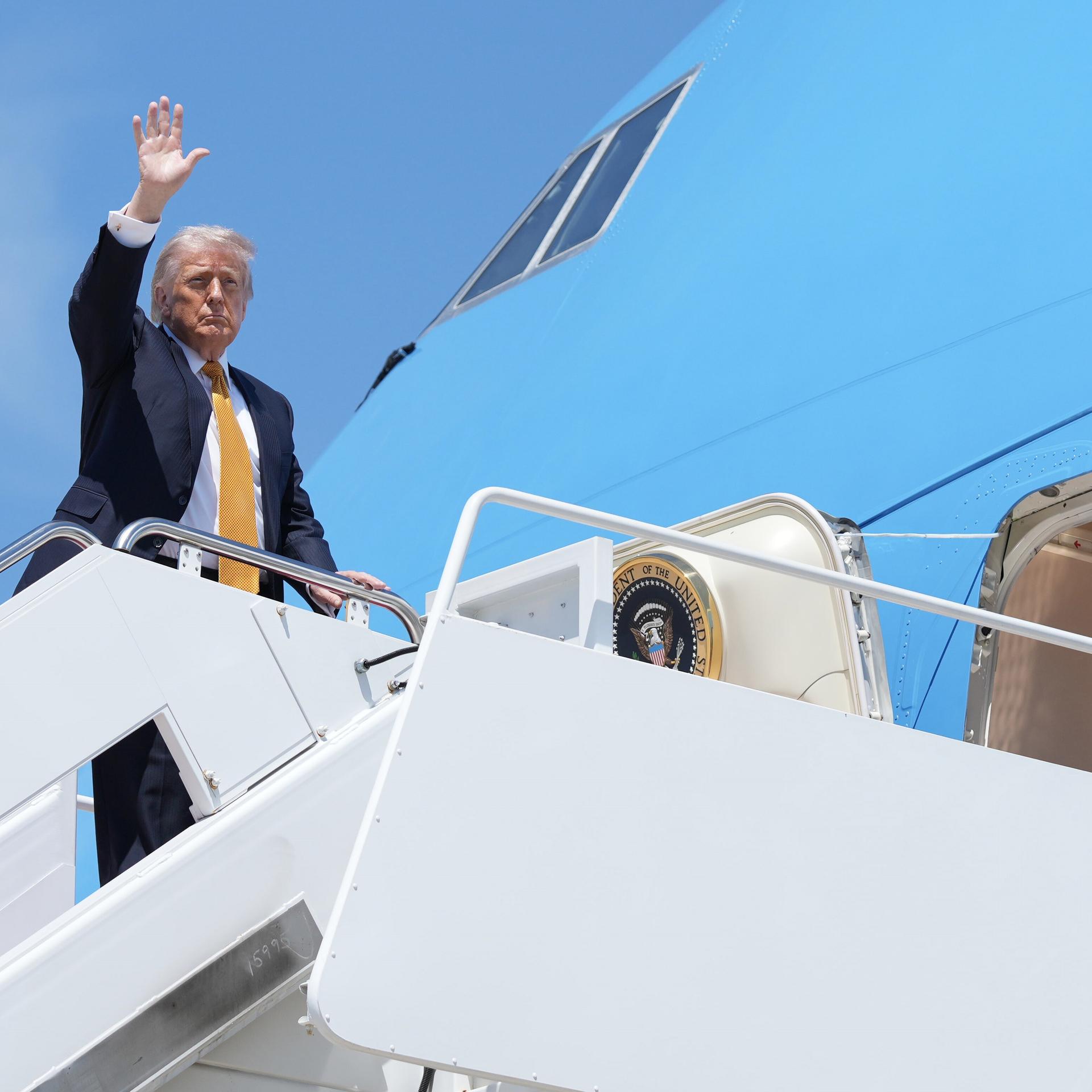 Das Foto zeigt Präsident Trump, als er eine Treppe zu einem Flugzeug hochgeht. 