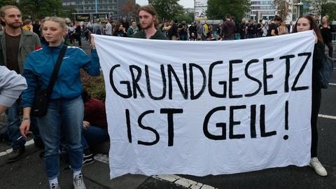 Zwei Personen halten am Rande eines Konzerts in Chemnitz ein Banner in der Hand mit der Aufschrift „Grundgesetz ist geil!“. 