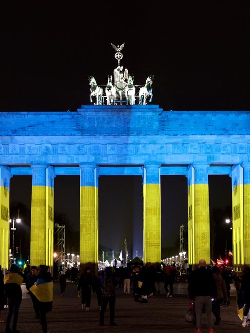 Das Brandenburger Tor wird in den Farben der ukrainischen Flagge angestrahlt, DEU, Berlin, 24.02.2023