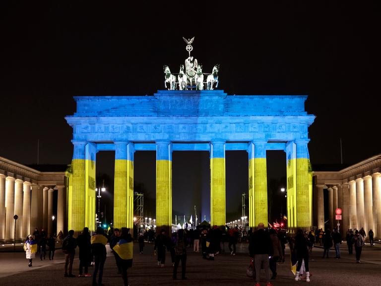 Das Brandenburger Tor wird in den Farben der ukrainischen Flagge angestrahlt, DEU, Berlin, 24.02.2023