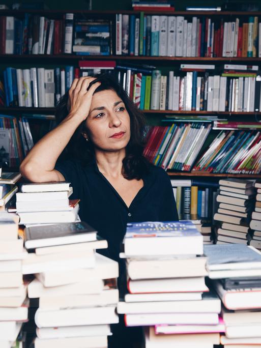 Die Autorin Asal Dardan posiert zwischen vielen Büchern