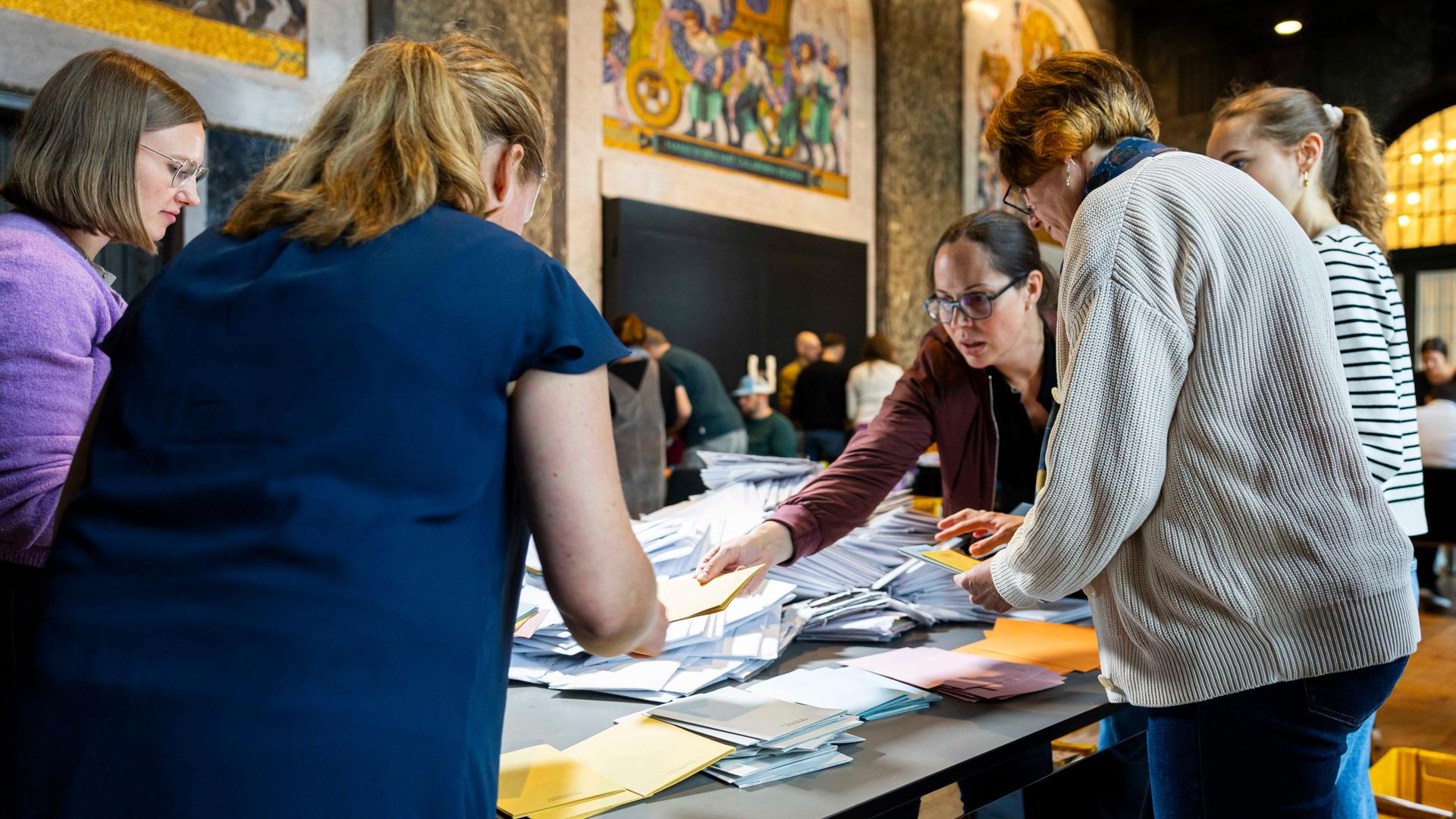 Wahlhelfer sortieren die Stimmzettel für die Auszählung der Briefwahl im Neuen Rathaus von Hannover. Wahlhelfer sortieren die Stimmzettel für die Auszählung der Briefwahl im Neuen Rathaus von Hannover.