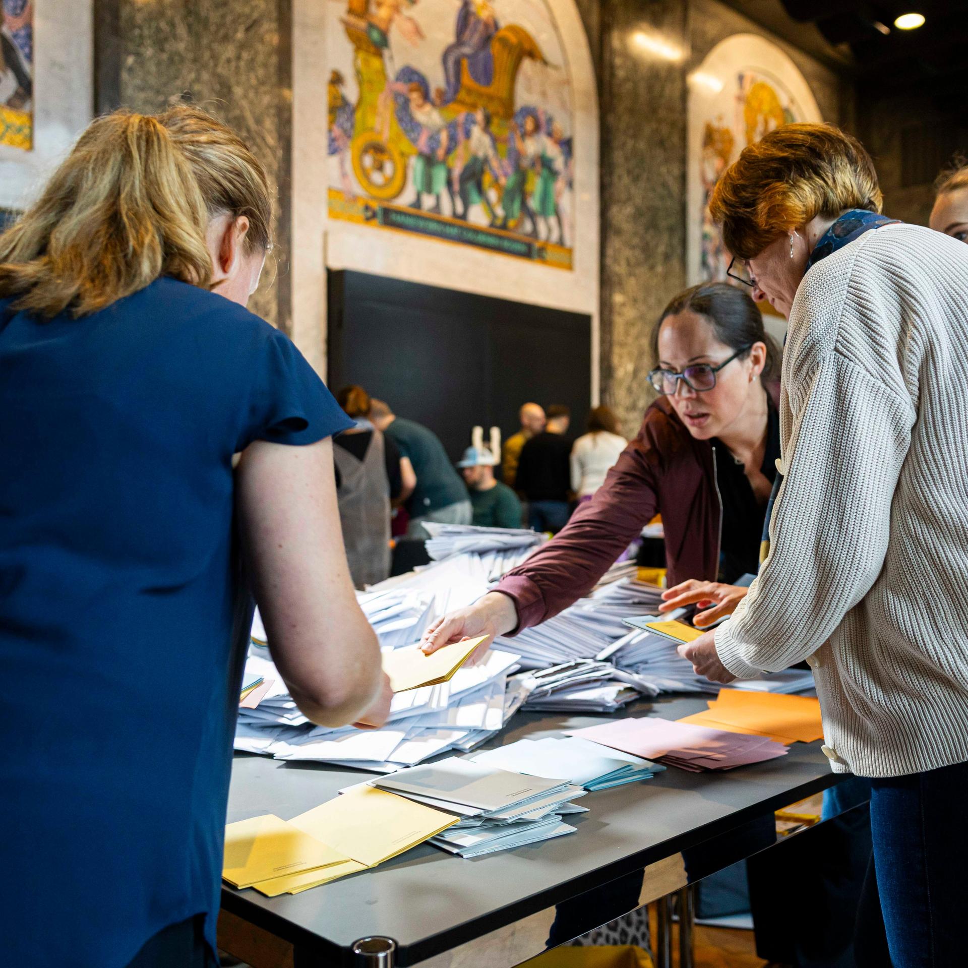 Wahlhelfer sortieren die Stimmzettel für die Auszählung der Briefwahl im Neuen Rathaus von Hannover.