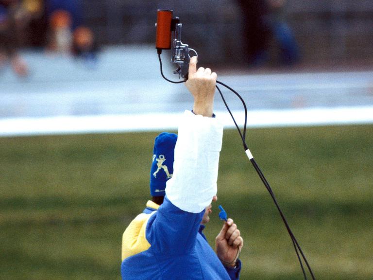 Der Starter hat den Finger am Abzug: Vor Abgabe des Startschusses bei einem Eisschnellaufwettbewerb in der damaligen DDR 1982 Der Starter hat den Finger am Abzug: Vor Abgabe des Startschusses bei einem Eisschnellaufwettbewerb in der damaligen DDR 1982