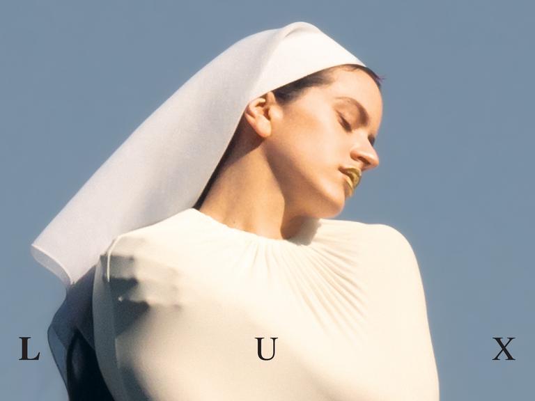 Auf dem Albumcover "Lux" ist Rosalia mit einer weißen Novizinnenhaube zu sehen. Ihre Arme sind unter einem weißen Oberteil verschränkt.