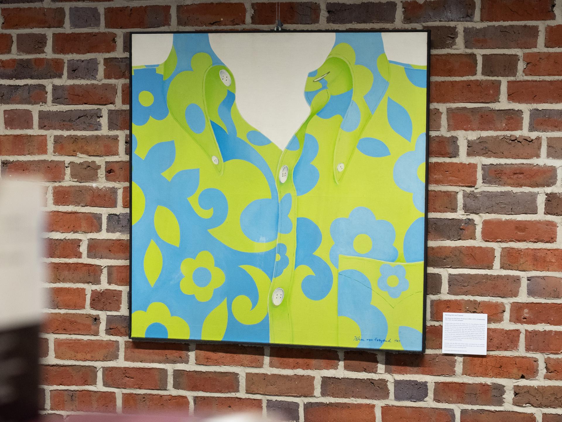 Das Bild „Das Hemd von Rolf Dieter Brinkmann“ von Henning John von Freyend ist zur Eröffnung einer neuen Dauerausstellung zum Leben des Schriftstellers Rolf Dieter Brinkmann in der Bibliothek der Universität Vechta zu sehen. Es hängt vor einer Ziegelwand.