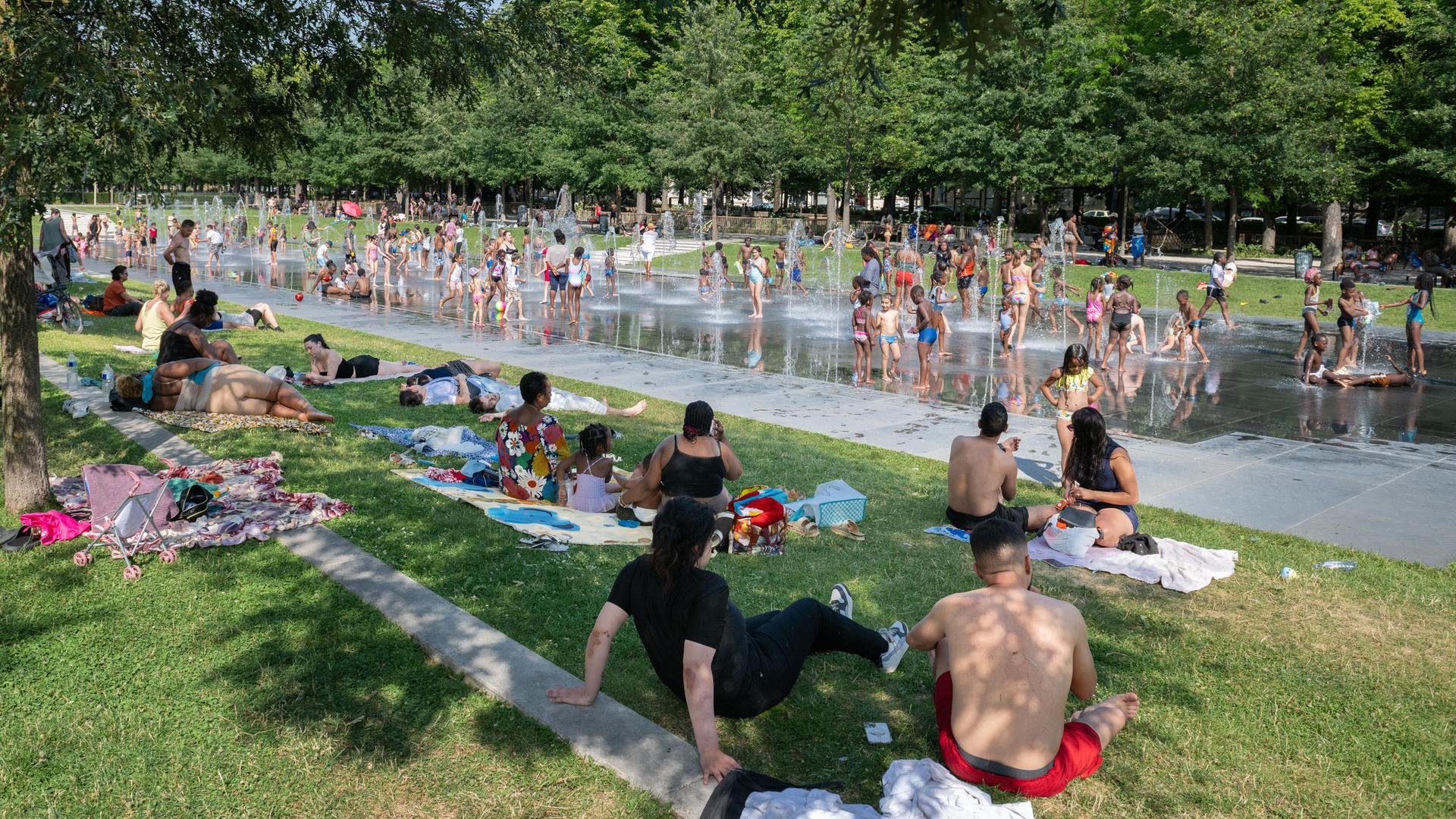 
Menschen kühlen sich während einer Hitzewelle an Sprühnebelstationen ab, die im Zuge steigender Temperaturen überall in Reims (Nordostfrankreich) aufgestellt wurden.