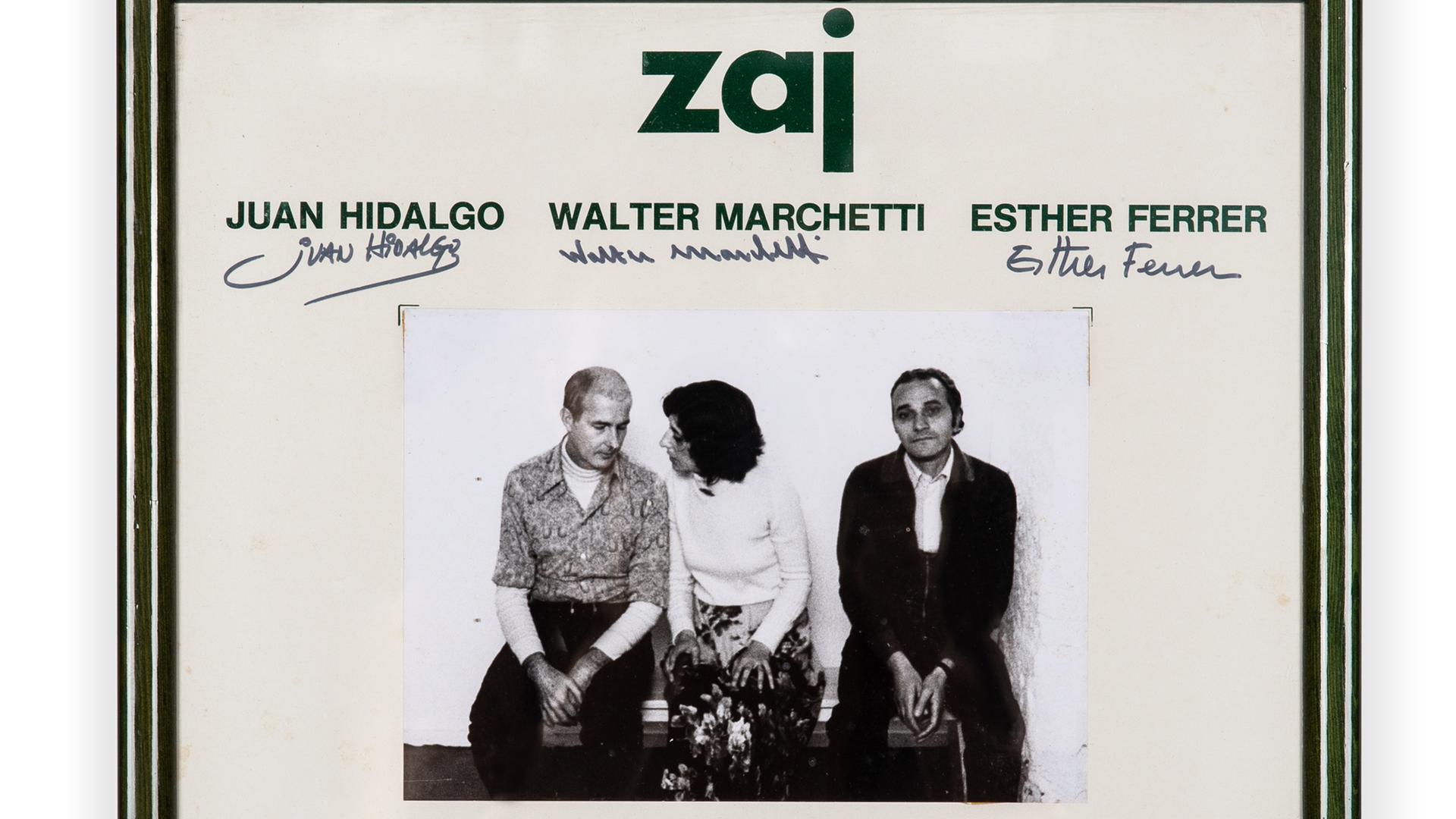 Eine gerahmte Einladungskarte zu einer Veranstaltung von "Zaj" mit einem schwarz/weiß-Foto von Juan Hidalgo, Walter Marchetti und Esther Ferrer
Eine gerahmte Einladungskarte zu einer Veranstaltung von "Zaj" mit einem schwarz/weiß-Foto von Juan Hidalgo, Walter Marchetti und Esther Ferrer
