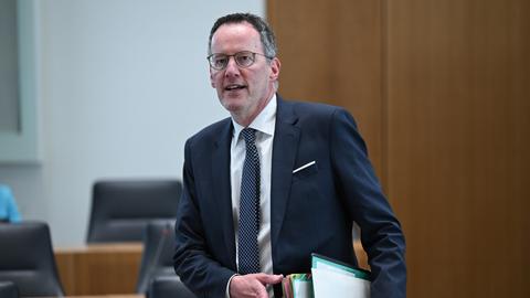 Der Innenminister von Rheinland-Pfalz, Michael Ebling, trägt Akten in seiner linken Hand.