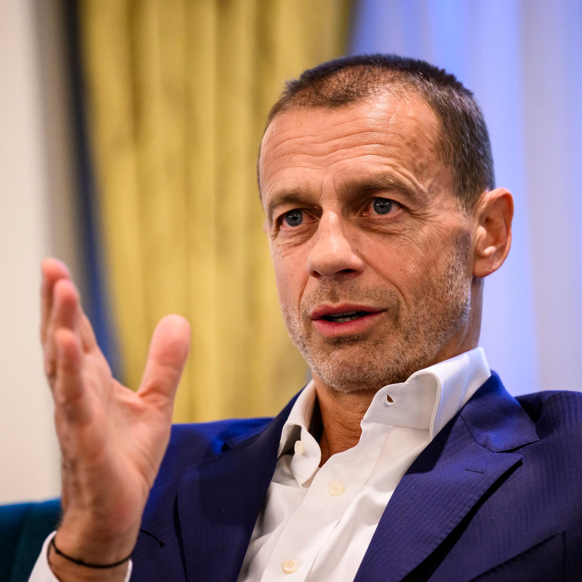 UEFA-Präsident Aleksander Ceferin gestikuliert sitzend.