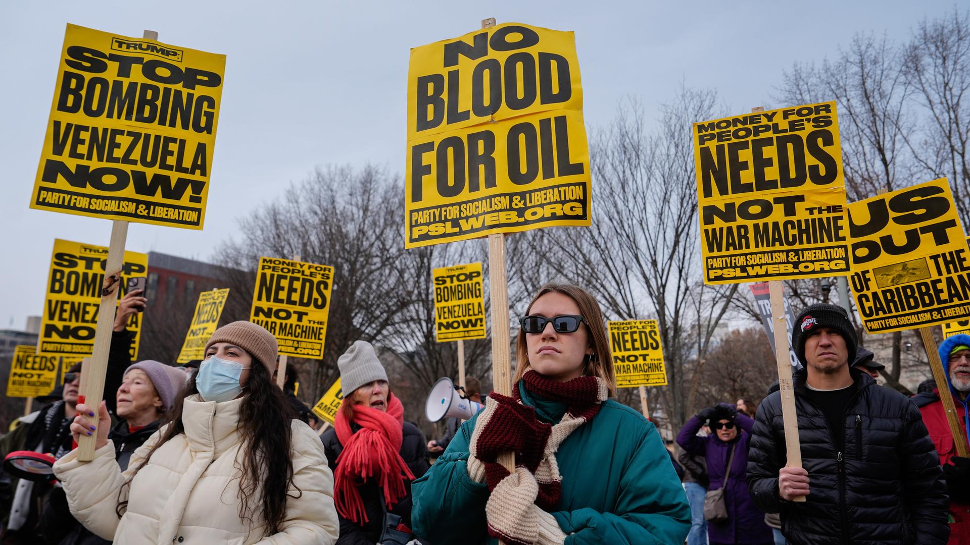 Menschen halten Schilder hoch mit der Aufschrift "no blood for oil" - "kein Blut für Öl".
