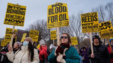 Menschen halten Schilder hoch mit der Aufschrift "no blood for oil" - "kein Blut für Öl".