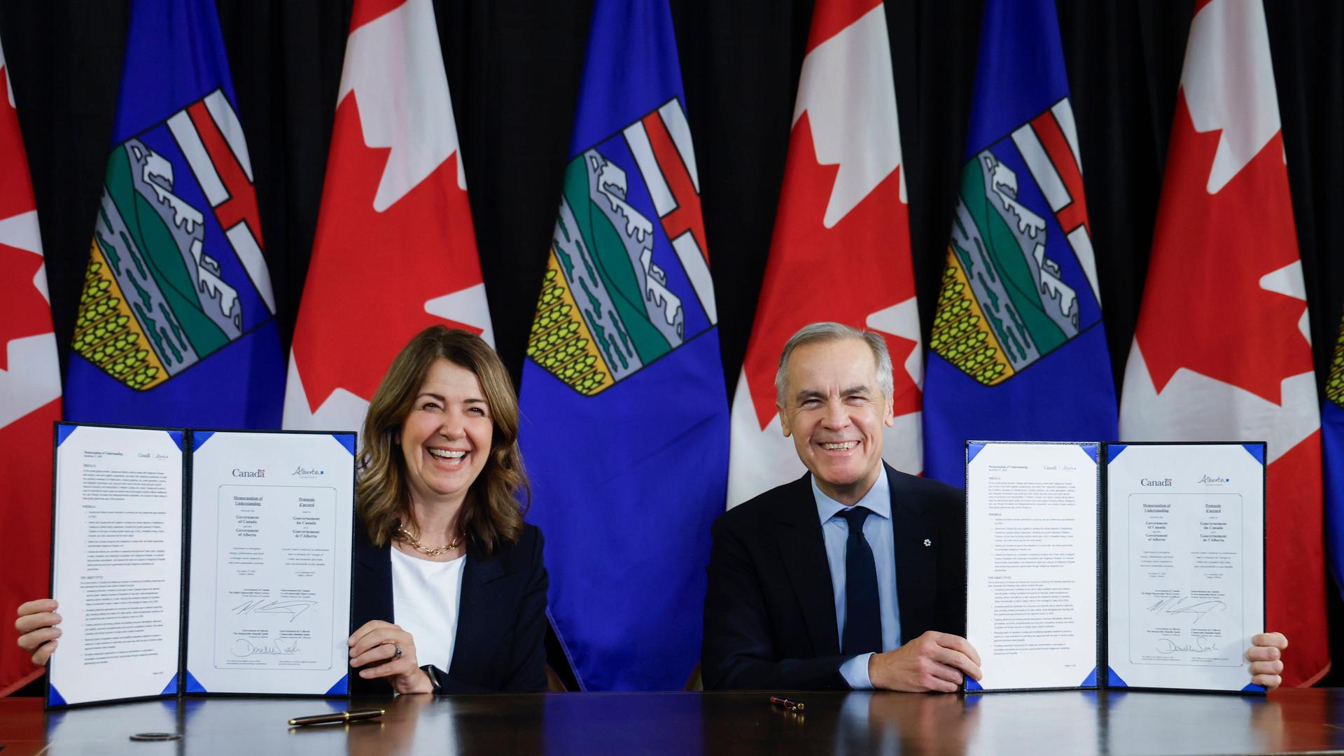 Kanadas Premierminster Carney und die Premierministerin der kanadischen Provinz Alberta, Smith, präsentieren die unterzeichnete Absichtserklärung.