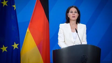 Bundesaußenministerin Annalena Baerbock bei einer Pressekonferenz im Auswärtigen Amt in Berlin. Sie steht an einem Redepult, links neben ihr die deutsche und die EU-Flagge.