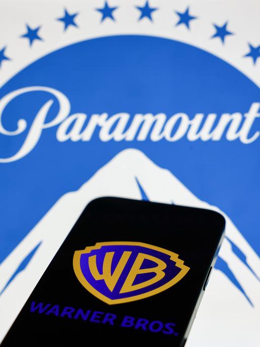 Das Paramount-Logo wird auf einem Laptop-Bildschirm und das Warner Bros.-Logo auf einem Handy-Bildschirm angezeigt.