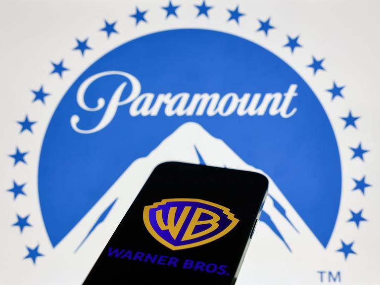 Das Paramount-Logo wird auf einem Laptop-Bildschirm und das Warner Bros.-Logo auf einem Handy-Bildschirm angezeigt.