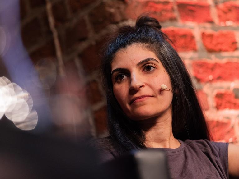 Die Schriftstellerin Shida Bazyar sitzt beim Literaturfestivals Lit.Cologne auf der Bühne. Die Schriftstellerin Shida Bazyar sitzt beim Literaturfestivals Lit.Cologne auf der Bühne.