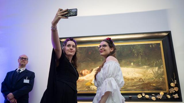 Das Foto zeigt 2 Mädchen, die sich vor dem Ophelia-Bild fotografieren.