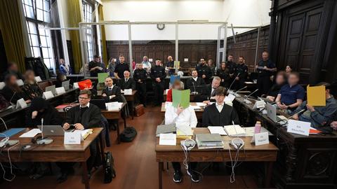Die Angeklagten des Prozesses gegen die rechtsextreme Terrorgruppe "Letzte Verteidigungswelle" verdecken ihre Gesichter mit roten, grünen und gelben Papierordnern im Hamburger Oberlandesgericht.