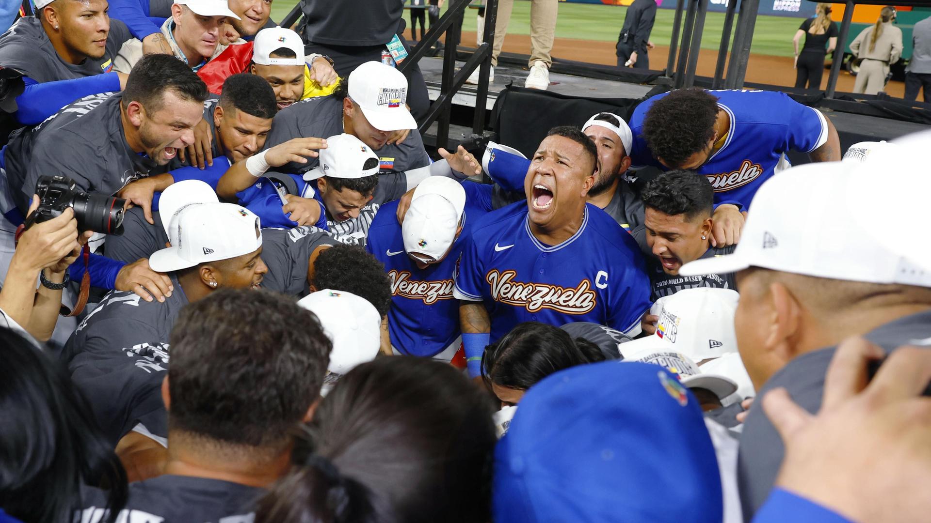 Spiele der Baseballmannschaft Venezuelas stehen zusammen und feiern, dass sie die Mannschaft der USA besiegt haben.