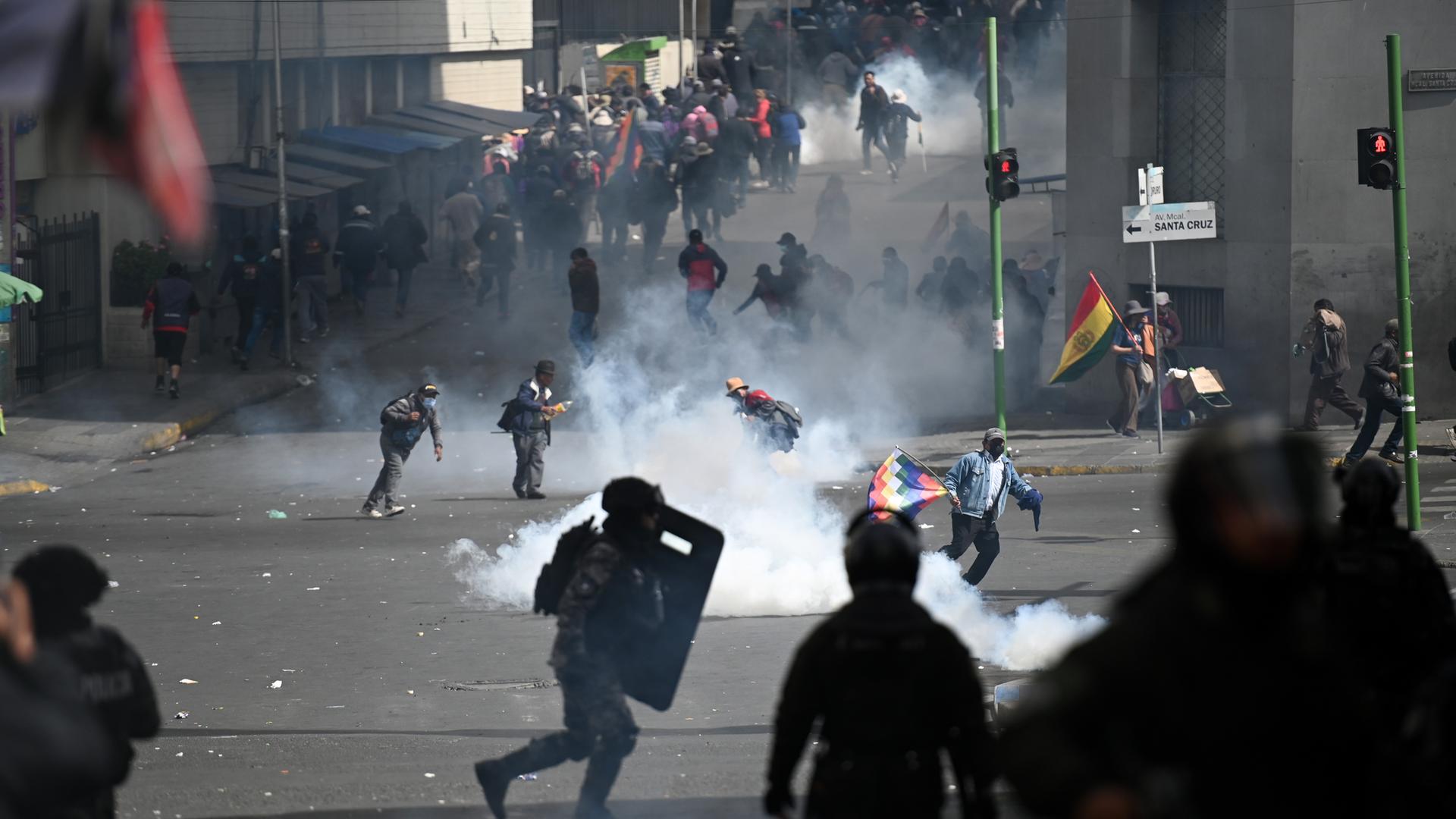 Bolivien, La Paz: Demonstranten fliehen vor dem von der bolivianischen Polizei eingesetzten Tränengas. 
