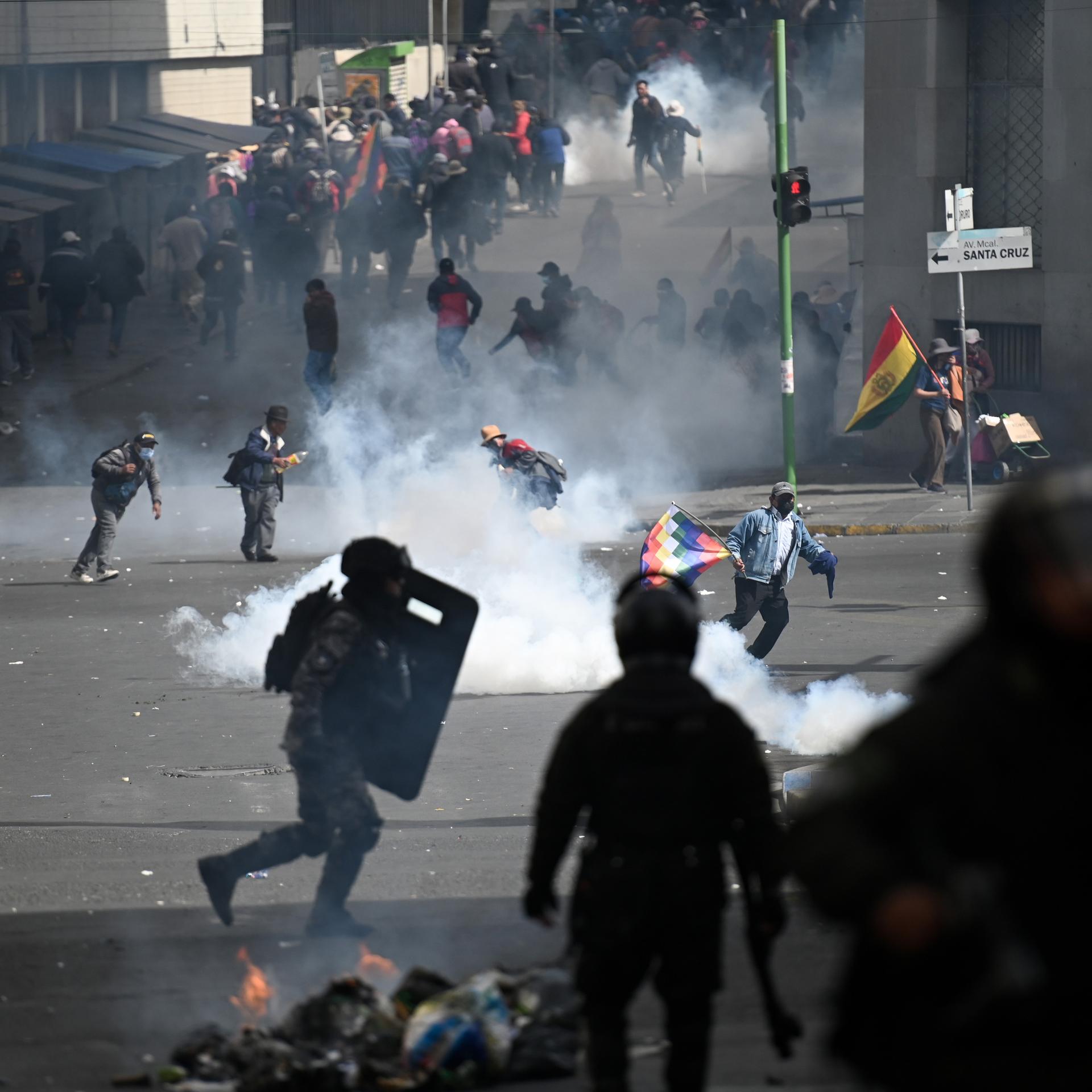 Bolivien, La Paz: Demonstranten fliehen vor dem von der bolivianischen Polizei eingesetzten Tränengas. 